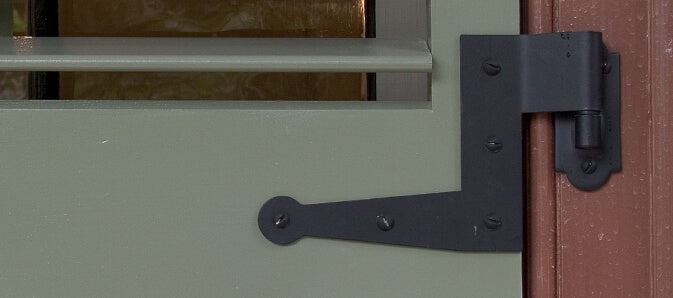Closeup photo of shutter hinge installed on green louver shutter.