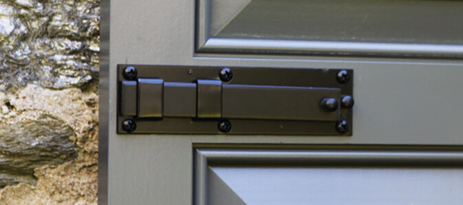 Closeup photo of exterior shutter lock installed on blue panel shutter.