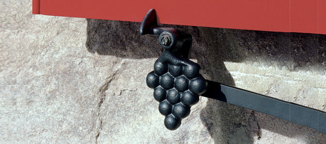 Closeup photo of grape shutter sil mount tieback installed on red panel shutter.