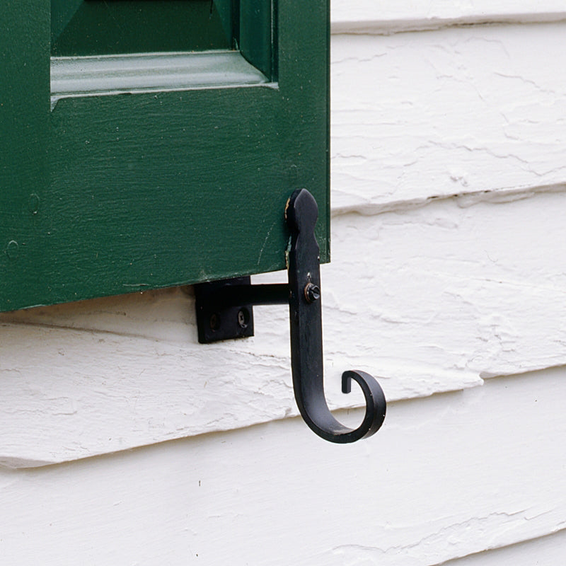 Closeup of Plate Mount Rat Tail Shutter Tiebacks with black powder coating installed on green panel shutter.