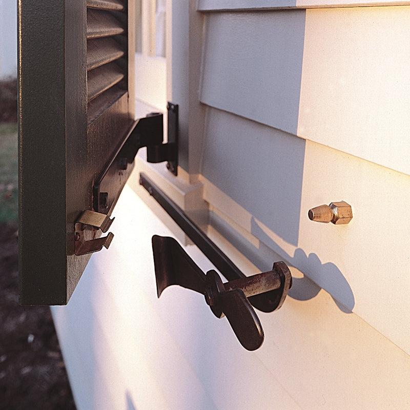 Closeup of installed Bullet Catch on black louver shutter and white vinyl house.