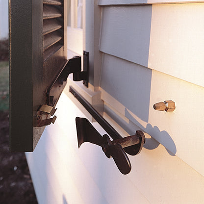 Closeup of installed Bullet Catch on black louver shutter and white vinyl house.